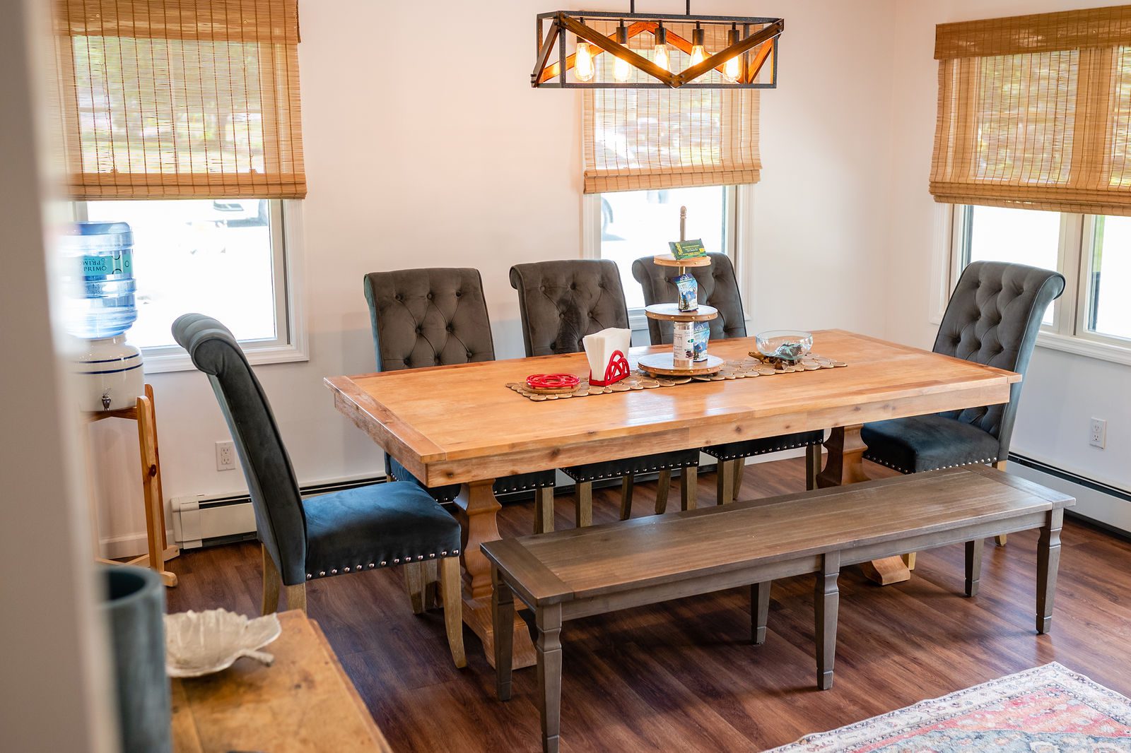 A dining room table with chairs and bench in the center.