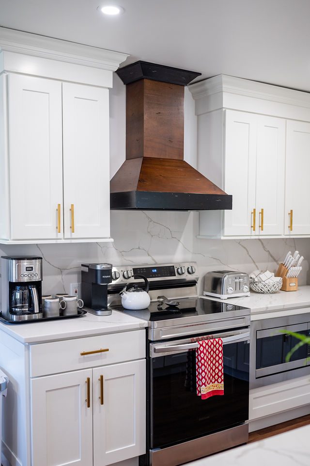 A kitchen with white cabinets and black appliances.